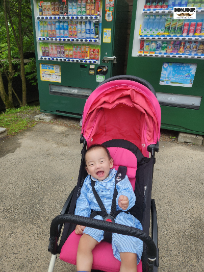 유모차를 타고 환하게 웃고 있는 아기의 모습