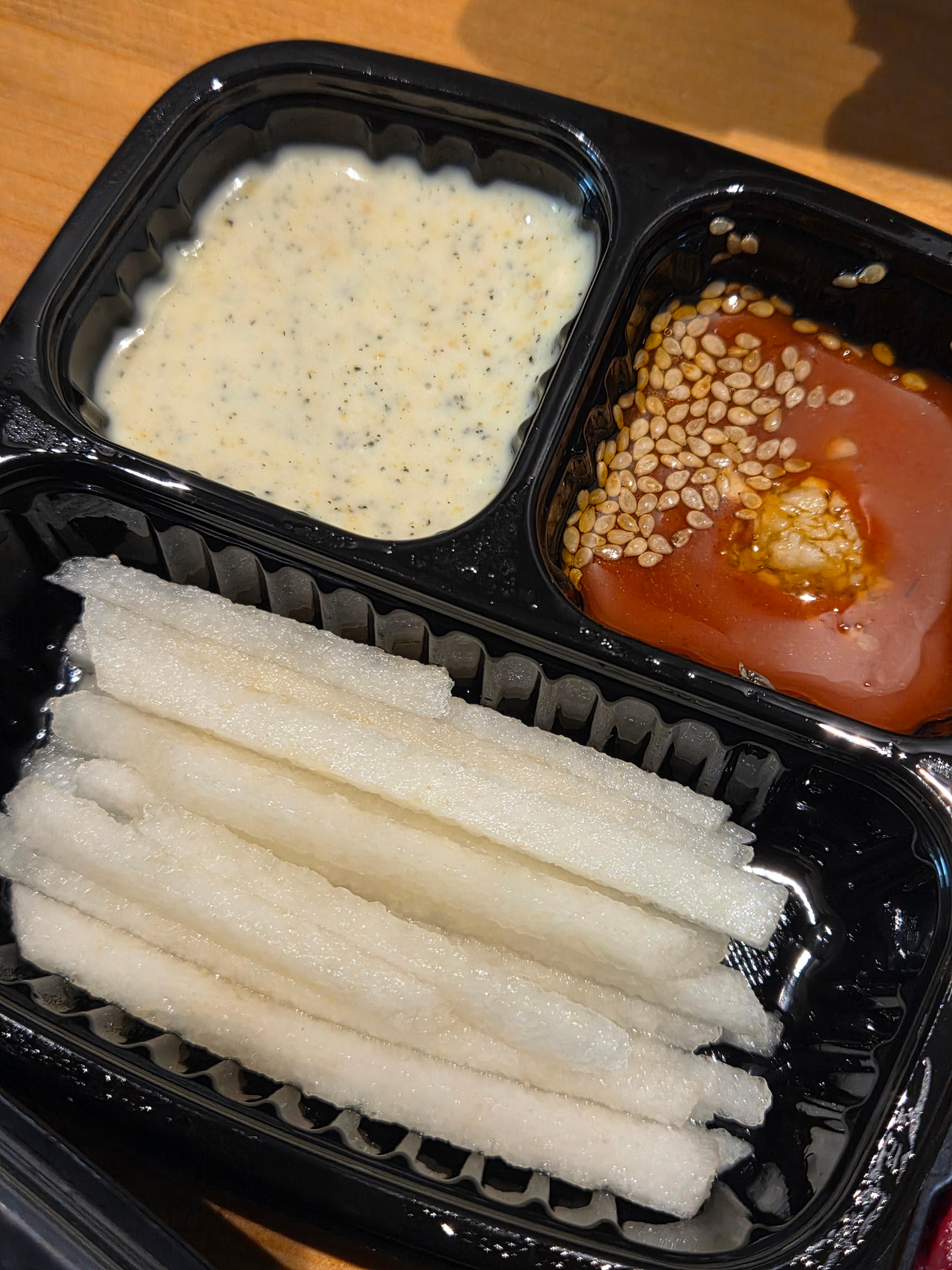 육회 곁들임으로 제공된 흑임자 참깨소스와 빨간 육회양념장 곁들여 먹는 과일 배가 가지런히 담긴 용기