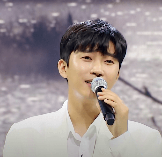 임영웅이 사랑의 콜센타 TV프로에서 흰색 수트를 입고 노래부르는 모습