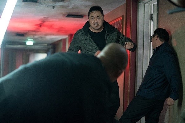 영화 《성난황소》에서 유괴된 아내를 되찾기 위해 불타는 분노로 범죄조직에 맞서는 주인공 동철(마동석 분). 복도의 붉은 조명처럼 분노도, 주먹도 멈출 줄 모른다.