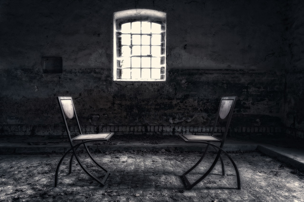 교도소 안 작은 창문과 의자 2개가 놓여 있는 이미지