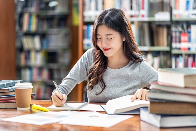 도서관에서 책을 보며 필기하는 여성