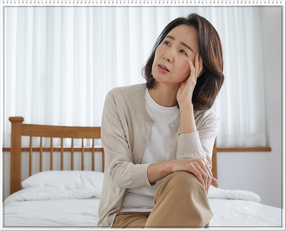 사선으로 시선을 올린 채 다소 힘겨운 표정을 짓고 있는 여성의 모습