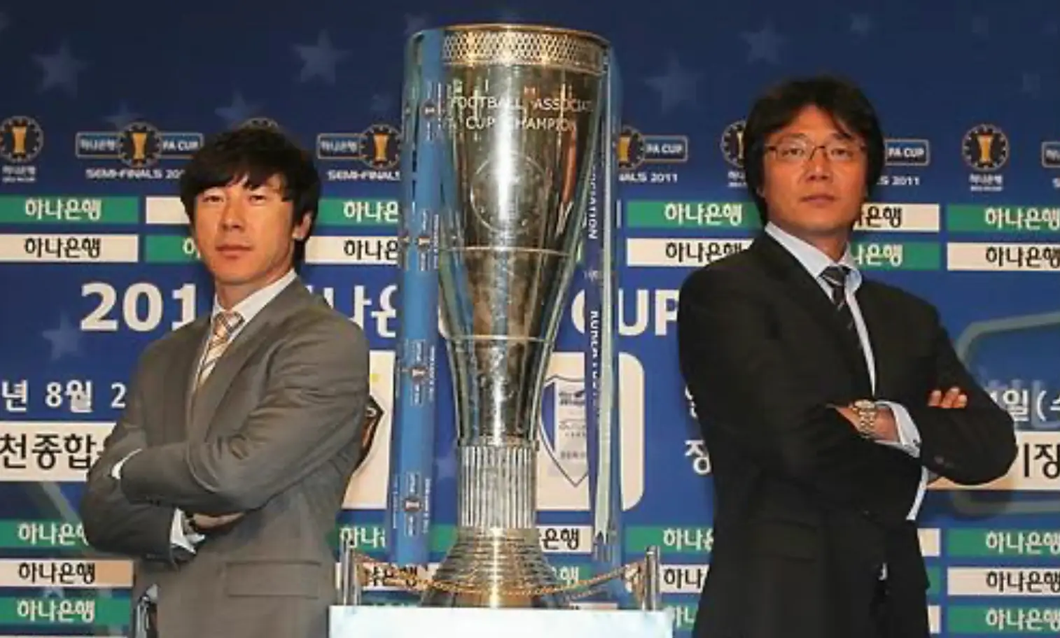 파리-은색트로피를 가운데 두고 좌측 회색 정장을 입은 신태용과 우측 검은 정장을 입은 황선홍 이 팔짱끼고 서있는 모습