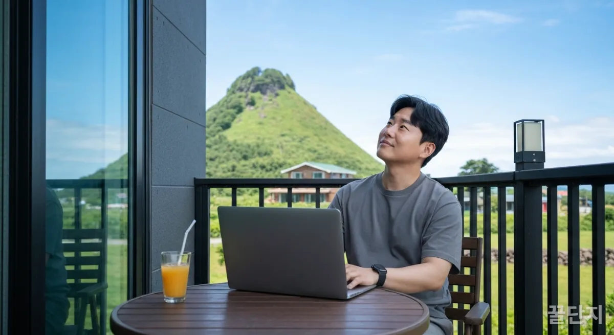제주 서귀포 게스트하우스 발코니에서 오름을 배경으로 워케이션 업무를 보는 한국인 남성