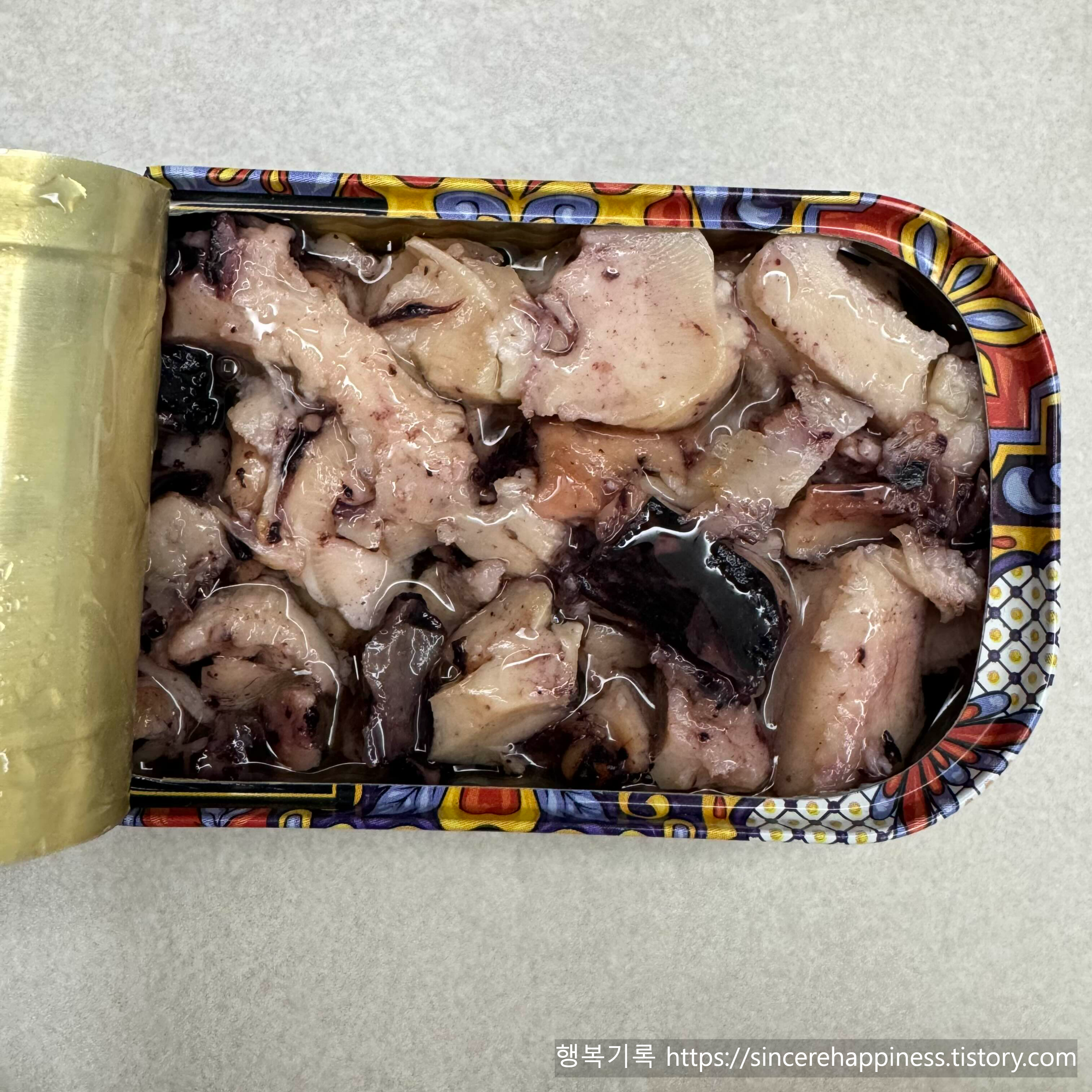 뚜껑을 연 트레이더조 올리브오일 통조림 속 통통하고 부드러운 오징어 조각