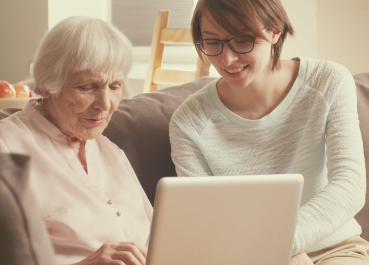 노인에게-컴퓨터를-보여주고있는-여성