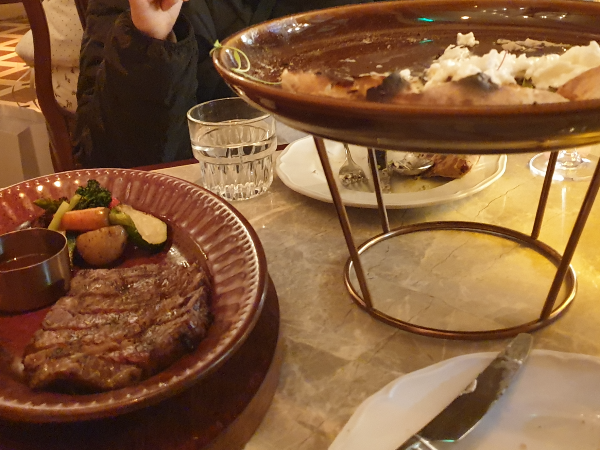 두 조각 먹은 스테이크와 다 먹어가는 피자.