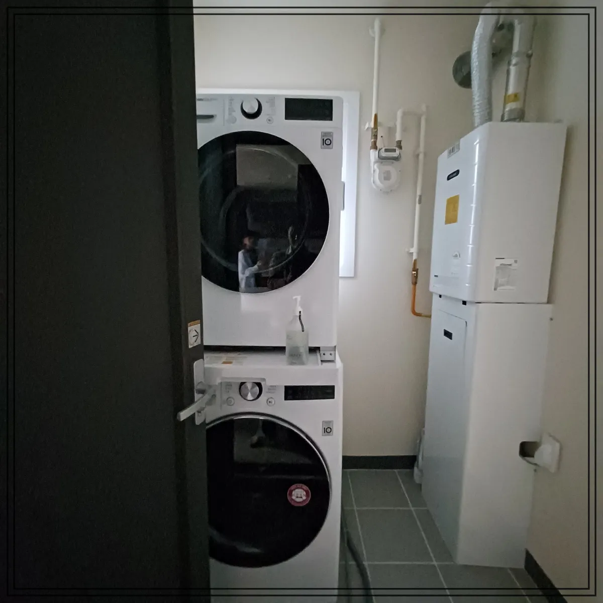 세탁기와-건조기가-있고-오른쪽에-보일러-있음-세탁실로-들어가는-진그레이-문도-함께-보임