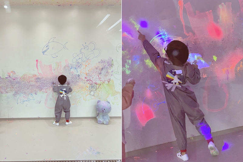 벽에 물감을 칠하고 있는 아이