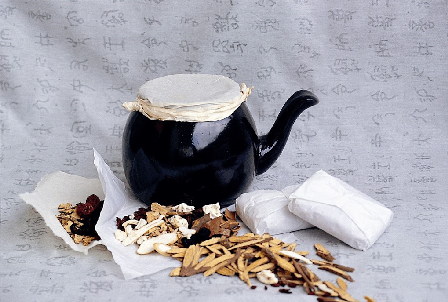 바닥에 예전 옹기 약탕기와 감초, 대추 등의 각종 한약재와 한약을 담은 첩약을 4첩을 같이 놓아두고 찍은 사진