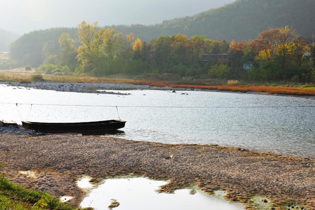 조용히 흐르는 강물, 정박해 있는 나룻배 한 척이 조용하게 시간을 음미하게 하는 정선 아우라지 이미지