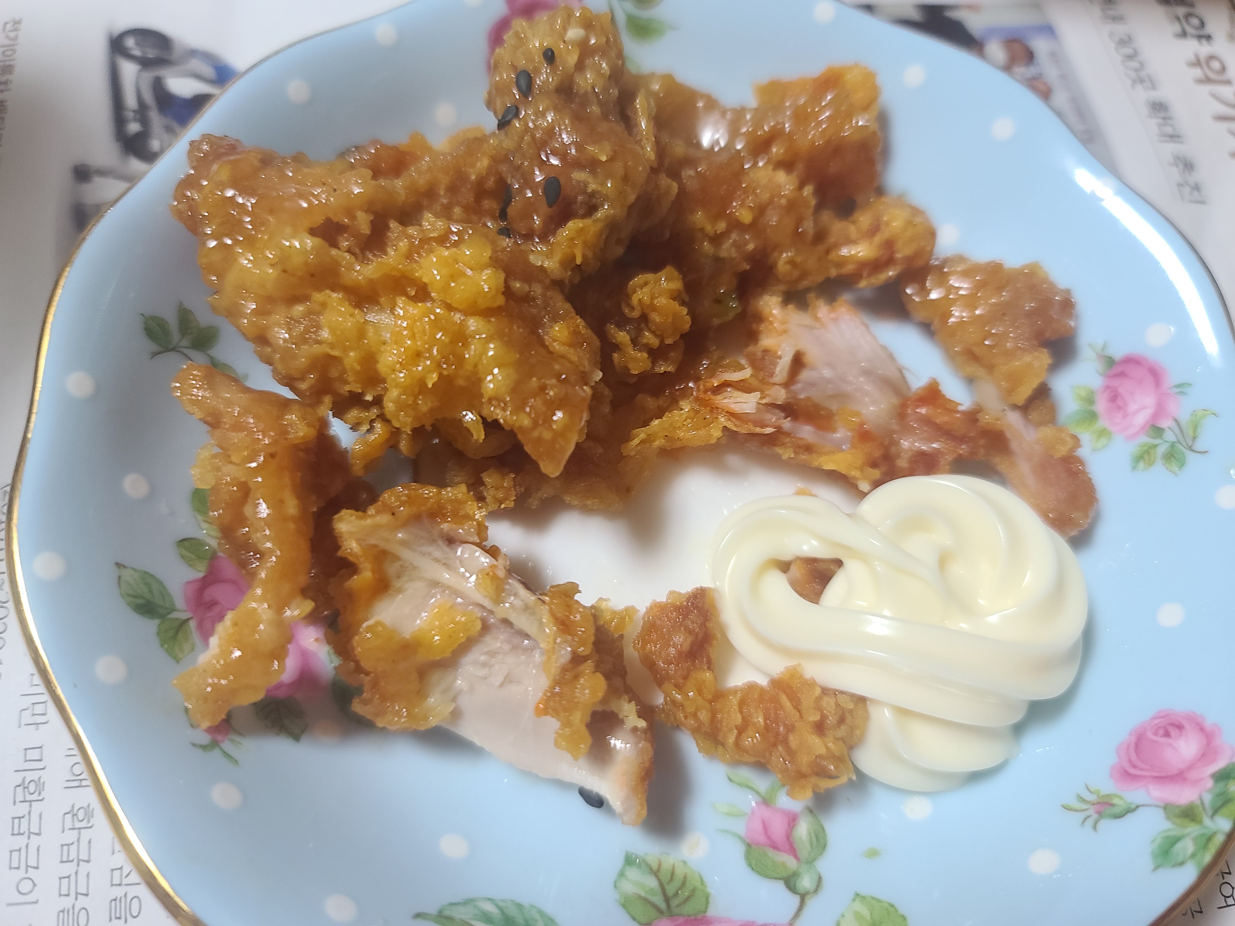 튀김옷이 두껍고 노릇한 치킨 조각 옆에 흰색 마요네즈가 곁들여져 있다.