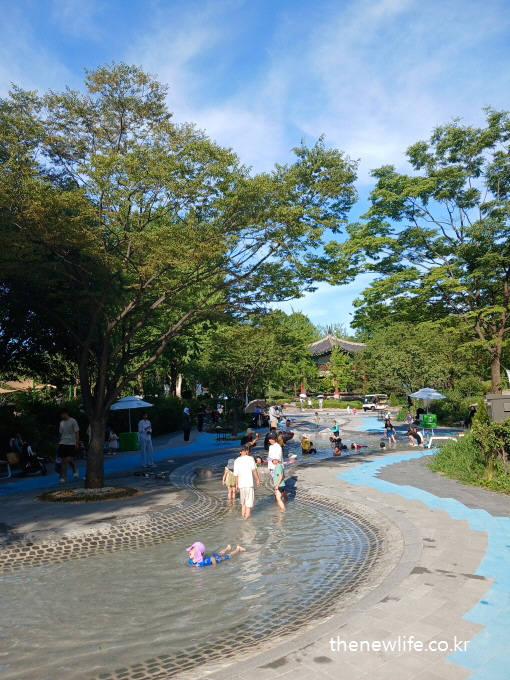 View of the toddler pool area with children and parents enjoying the water/어린이와 부모들이 물놀이를 즐기고 있는 서울 어린이 대공원 유아 수영장 전경