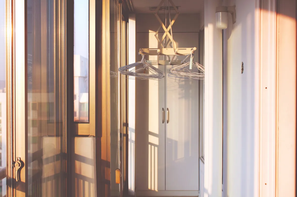 노을이지는시간-주황색빛이드는베란다-빨래건조대-옷걸이-베란다창문밖으로아파트건물이보이는