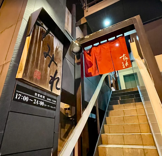 가게 간판이 나무로 되어 있고 가게로 올라가는 계단이 나와 있는 사진