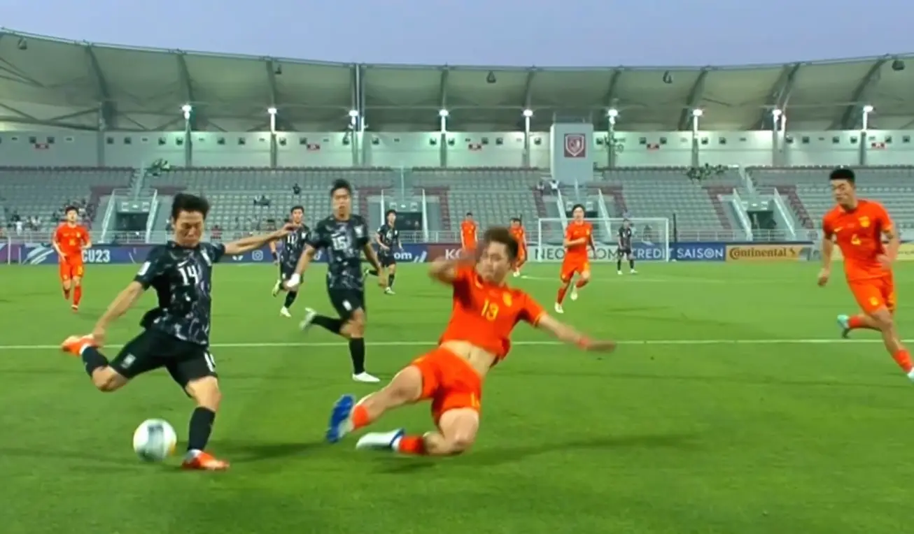 u23-이영준이 공을 강하게 치고 있고 중국팀은 슬라이딩하며 막는모습