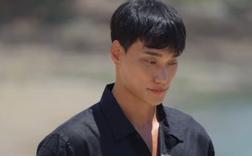 솔로지옥3- 검은색 셔츠를 입고 땅을 바라보며 서있는 최민규