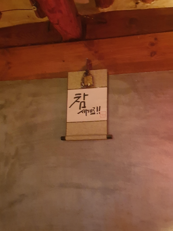 나무보 아래 시멘트 벽면에 참 세계로라는 표어가 붙은 두루마리가 부착되어 있다.