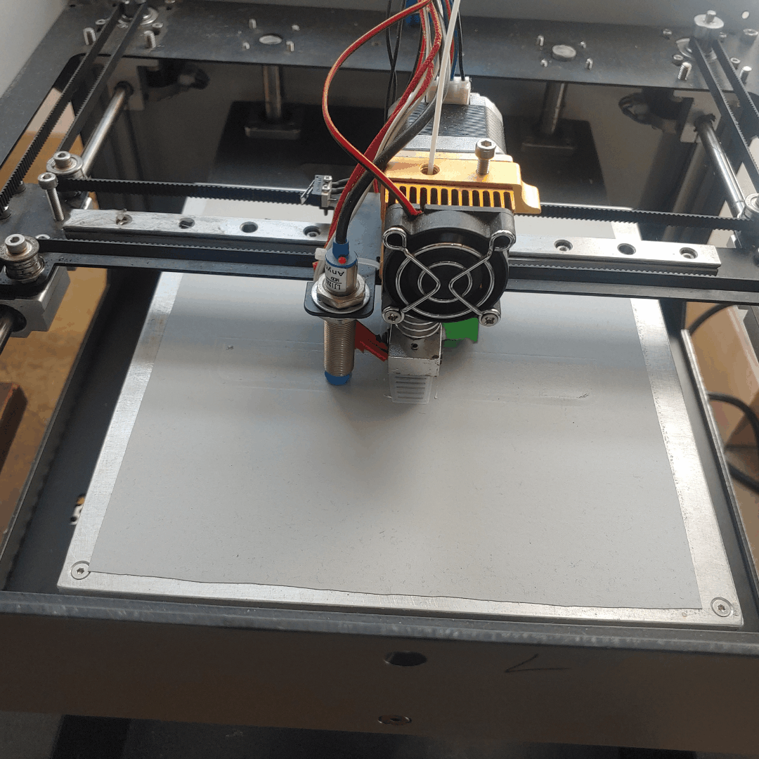 3D프린터가 베드 위에서 첫 번째 레이어를 출력하며 밑바탕을 그리는 모습.