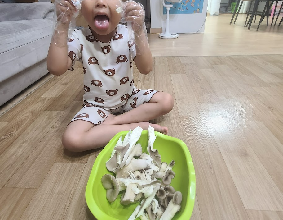 직접 키운 버섯을 수확하고 성취감을 느끼는 초등학생 아이의 모습