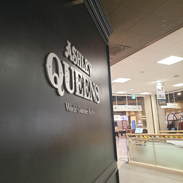 검은색 벽면에 애슐리퀸즈라는 간판이 써있다.