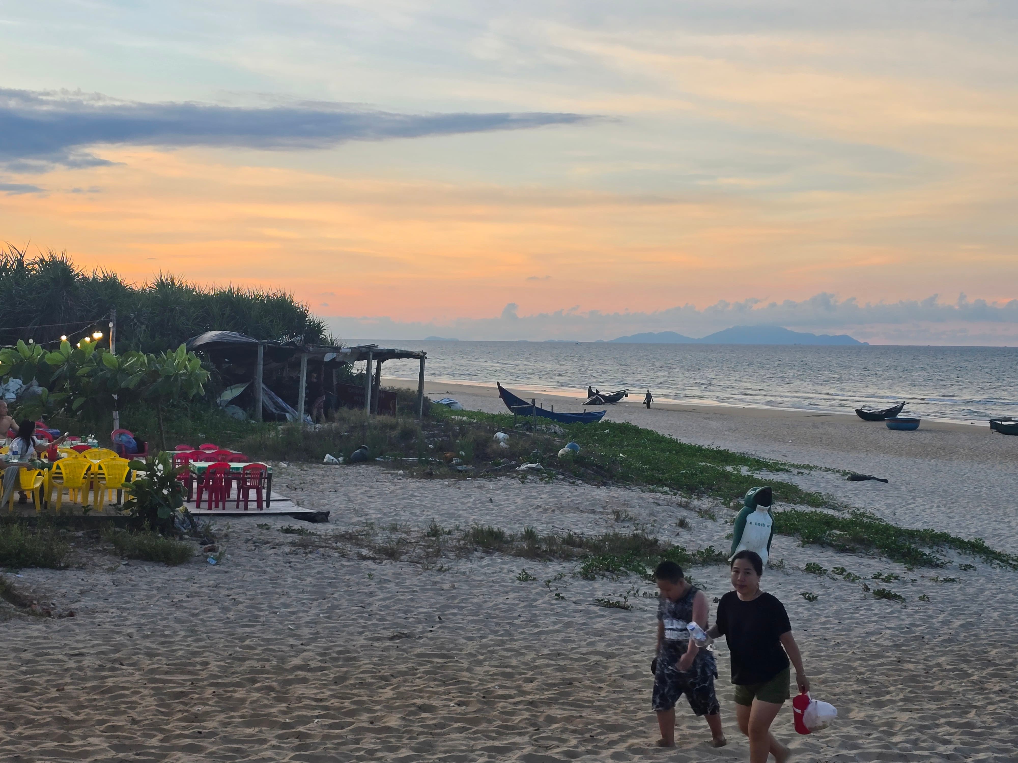 다낭 해변의 노을빛과 산책하는 사람들
