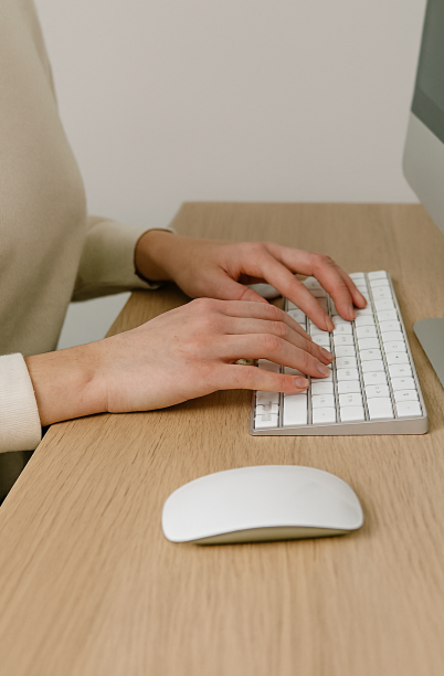 책상 앞에서 올바른 손목 자세로 키보드를 치는 장면