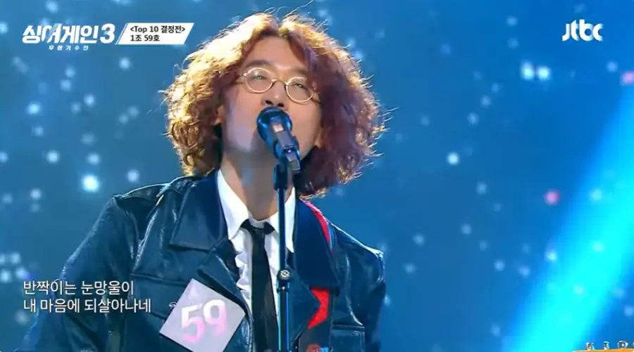 싱어게인3-
파란배경 무대 파란자켓 흰셔츠 넥타이 노란파마머리 금테안경을 쓰고 노래하는 59호