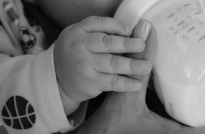 아기가 젖병을 잡고 분유를 먹는 모습, 모유 vs 분유 선택 기준과 영양 비교 관련 육아 이미지