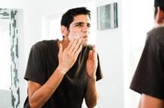 검은-옷을-입은-남성이-얼굴에-거품질을-하고-거울을-바라보는-모습