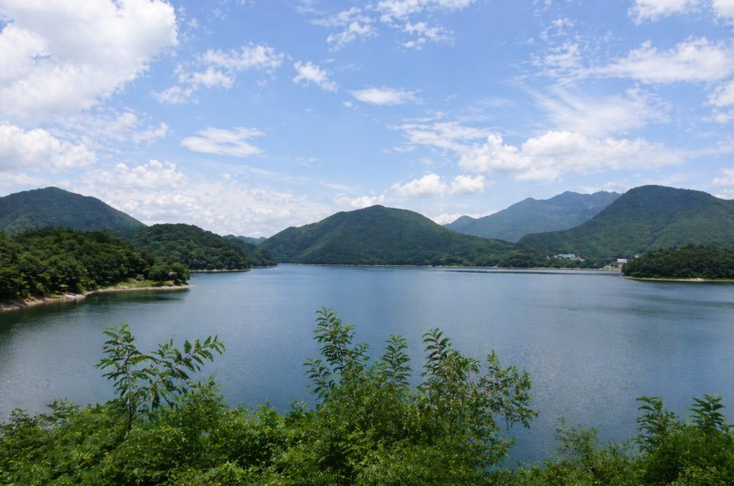 괴산호의 넓은 수면과 산 능선, 잔잔한 호수 풍경이 함께 보이는 모습