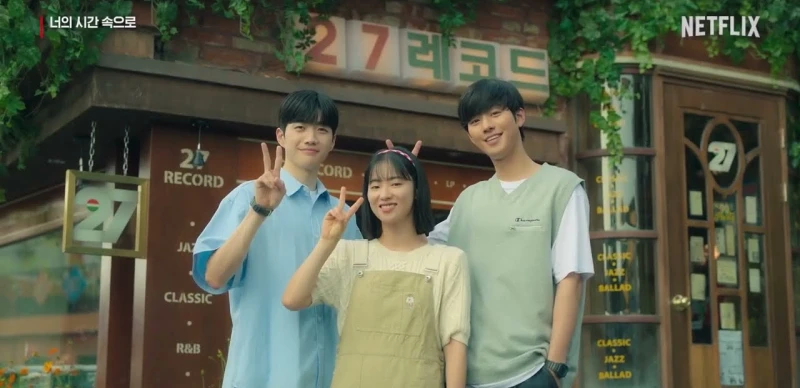 1998년 레트로풍이 느껴지는 27레코드 가게를 배경으로 너의 시간 속으로 남녀 주인공 남시헌, 권민주, 정인규 세명이 함께 사진을 찍고 있는 장면