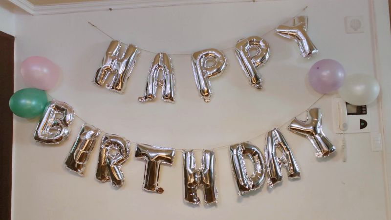 레터링 풍선과 풍선을 노끈과 시침핀으로 벽에 장식한 사진