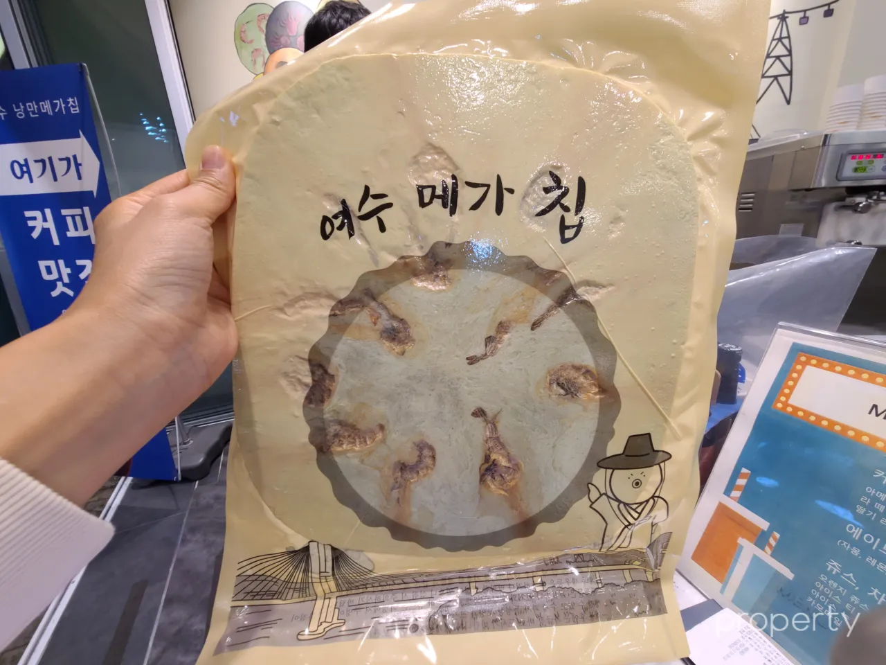 여수-디저트-베이지색봉투-납작동글한모양의-메가칩-과자안에새우가박혀있는모습