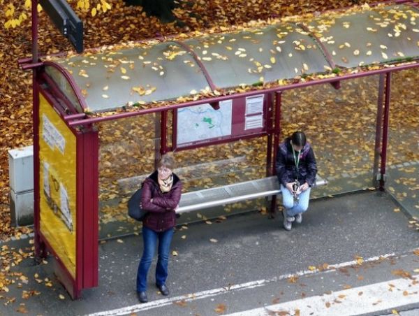 버스정류장에서 버스를 기다리는 두사람