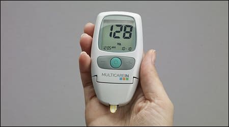 혈당 체크기를 들고 있는 손