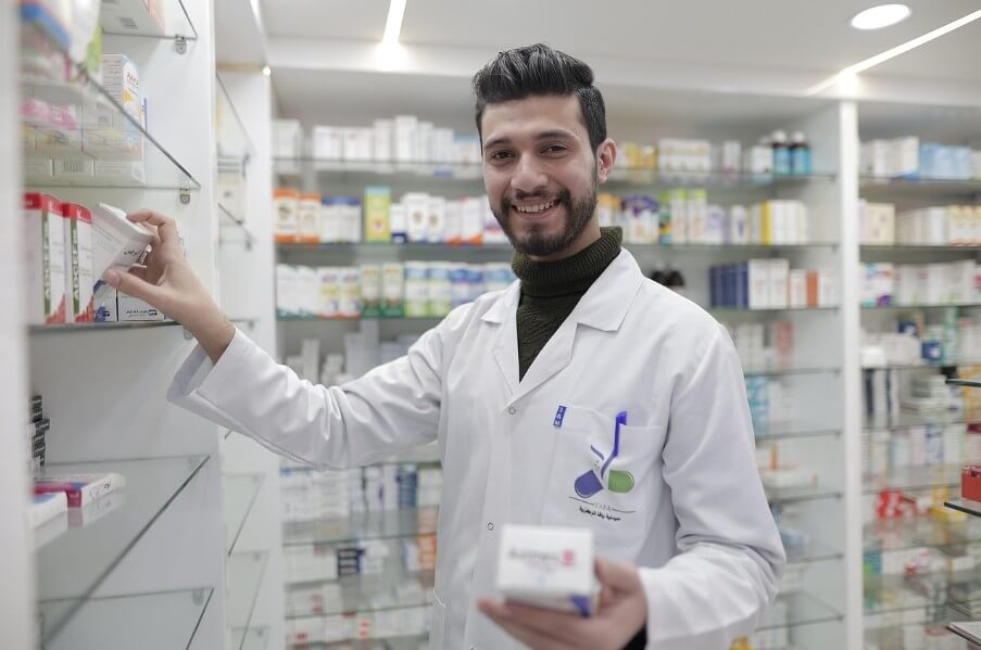 약사가 약을 가르키며 웃고 있는 모습