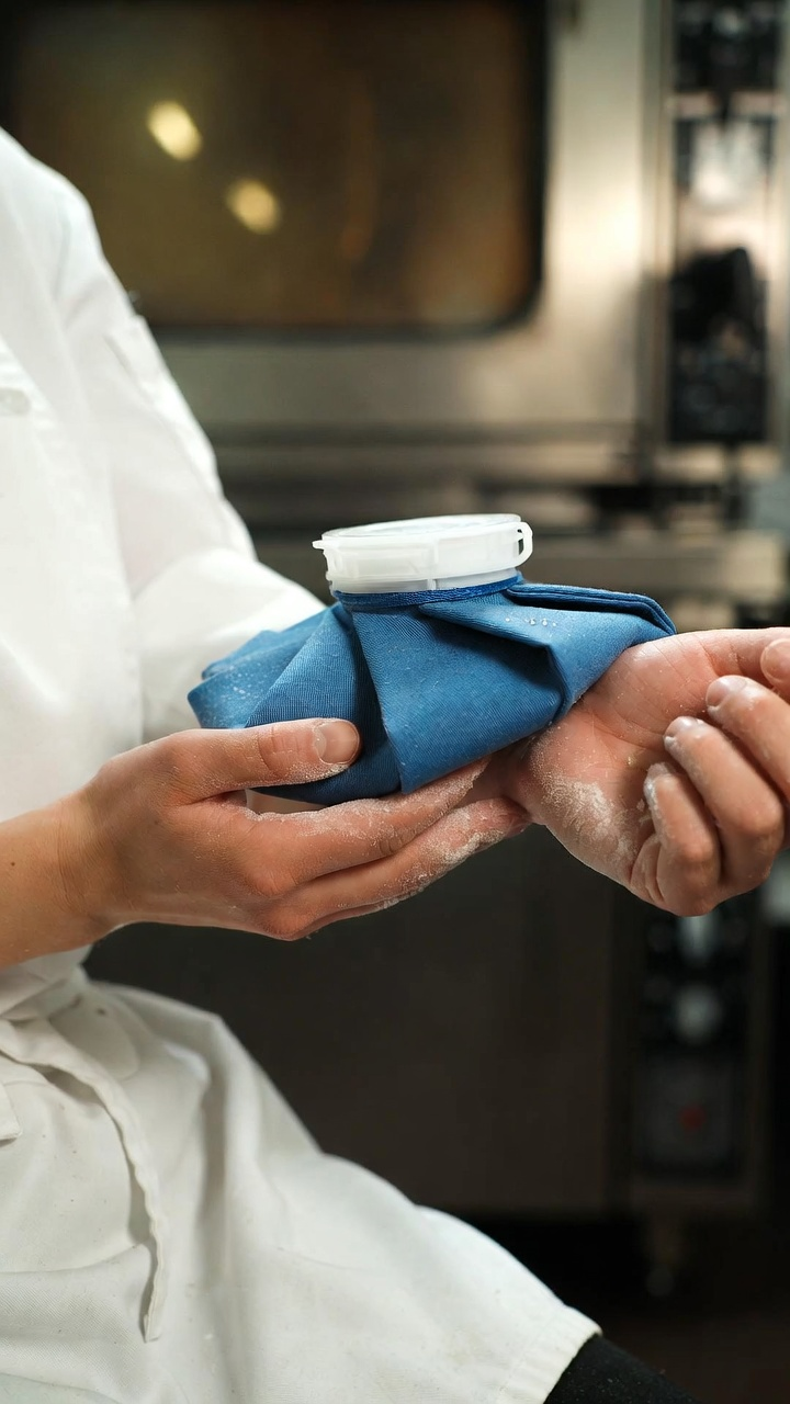 밀가루가 묻은 손으로 얼음주머니를 잡고 열감을 식히려는 모습