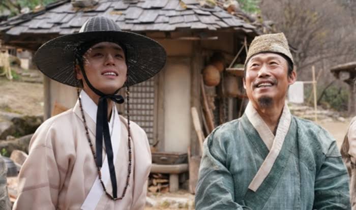 영화 <왕과 사는 남자>에서 박지훈(어린 왕 이홍위)과 유해진(엄흥도)이 나란히 서서 밝은 표정으로 어딘가를 바라보고 있는 스틸컷