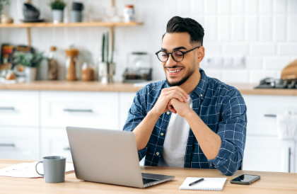 노트북화면을 응시하며 웃고있는 청년