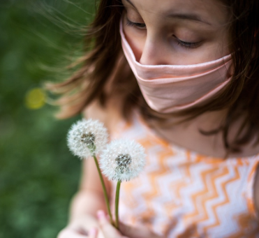 마스크를 쓰고 민들레씨를 들고 있는 모습