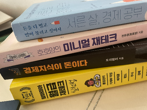 경제와 재테크 관련된 책이 쌓여 있는 사진 이미지 입니다.