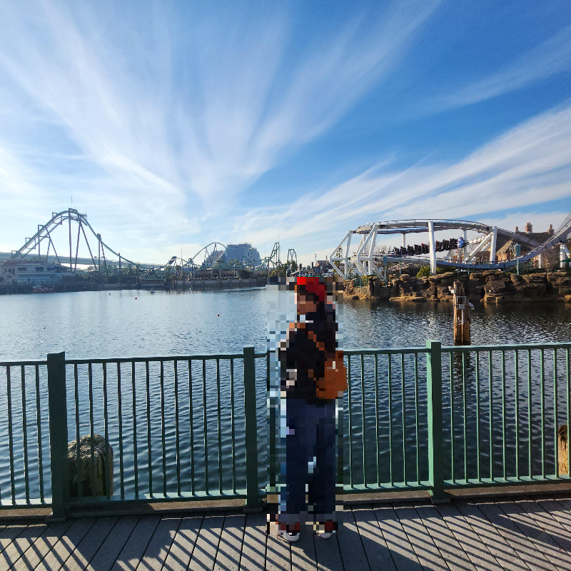 멀리 어트랙션이 보이고 그 앞은 물이 강처럼 보인다.