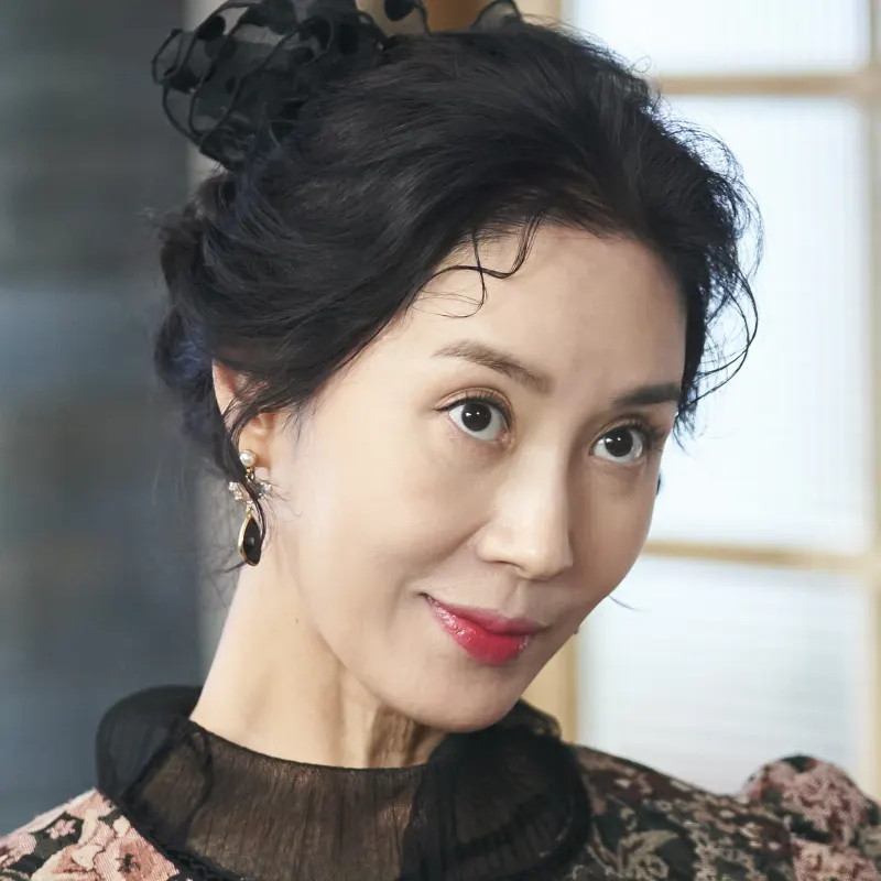 어느 실내를 배경으로 검은 드레스를 입고 미소짓는 오랫동안 당신을 기다렸습니다의 피장미