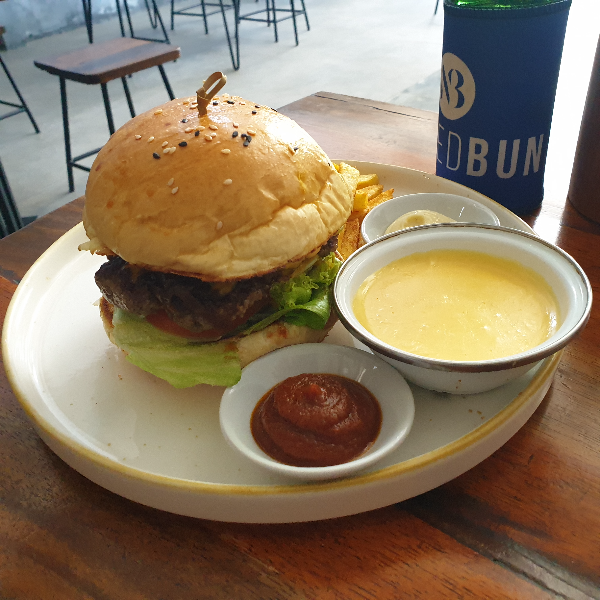 햄버거 옆에 치즈가 들어있는 그릇이 보인다. 캐첩과 함께