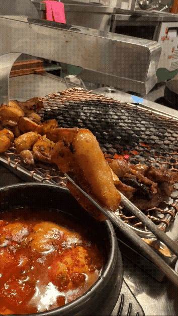 세광양대창 정자점에서 젓가락으로 대창을 집어 매콤한 양념장에 찍는 장면&amp;#44; 윤기와 불향이 어우러진 고소한 대창 클로즈업 gif