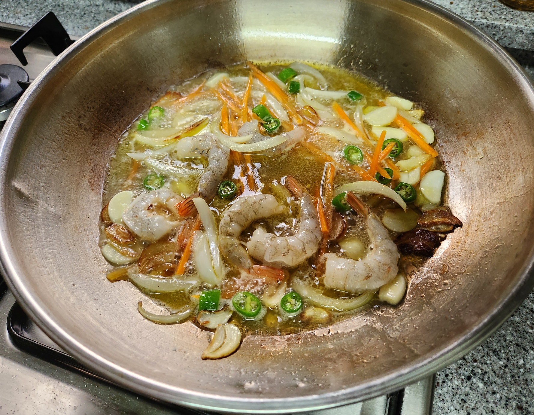 야채와 새우를 볶고 있는 상태를 보여주는 이미지