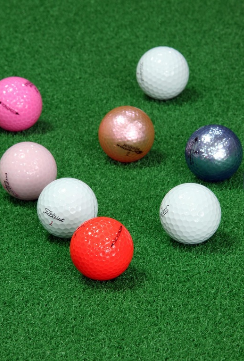 인조잔디위에 색색깔의 골프공이 여러개 있는 이미지