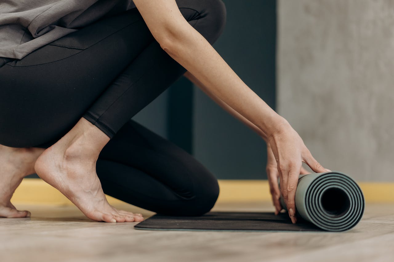 A youth baseball player practicing infield footwork on a yoga mat in a living room.